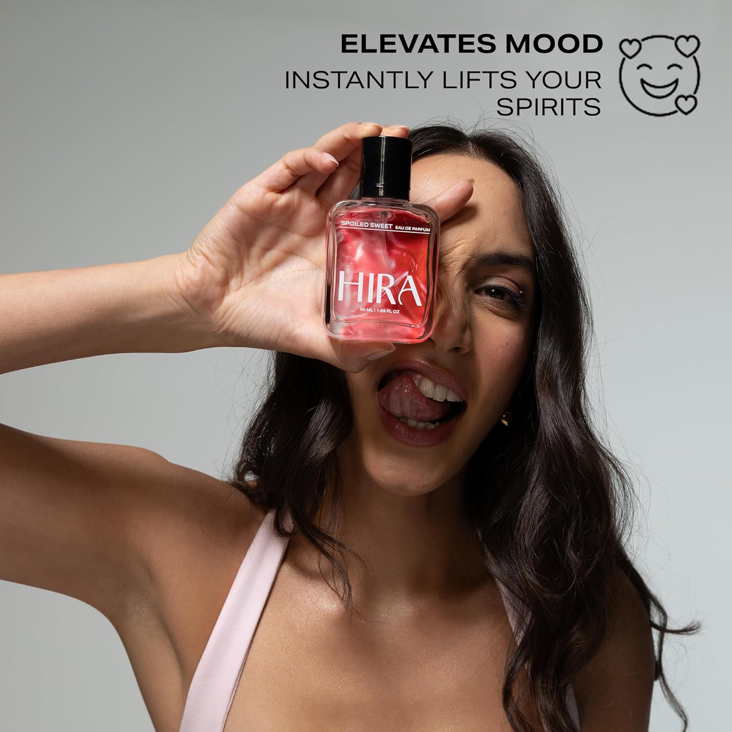 Woman holding a red bottle labeled 'Hira' with promotional text on a gray background