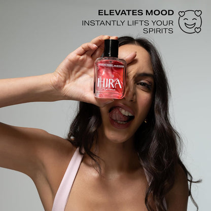 Woman holding a red bottle labeled 'Hira' with promotional text on a gray background