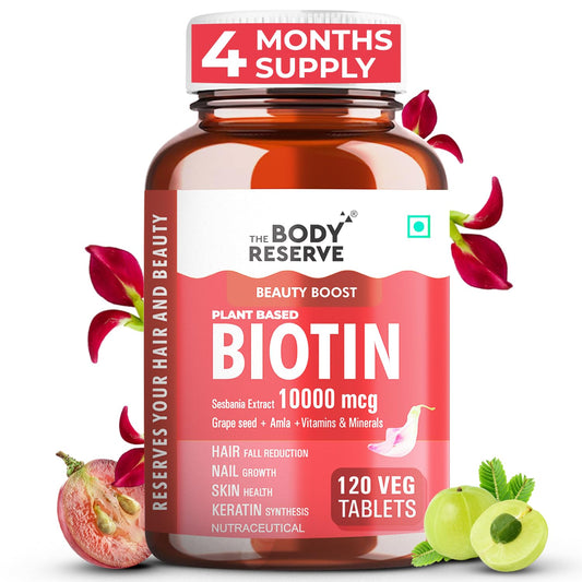 Bottle of The Body Reserve Biotin supplement with red flowers and green apples on a white background