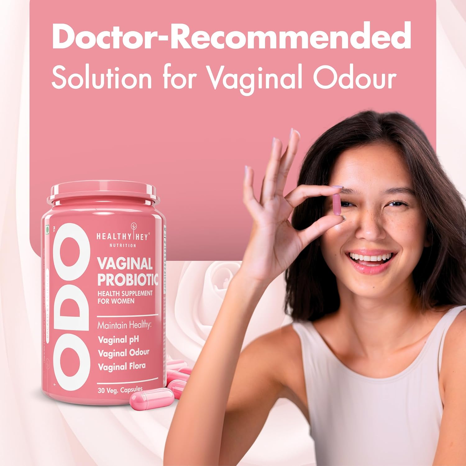 Woman holding a container of ODO Vaginal Probiotic with a pink background