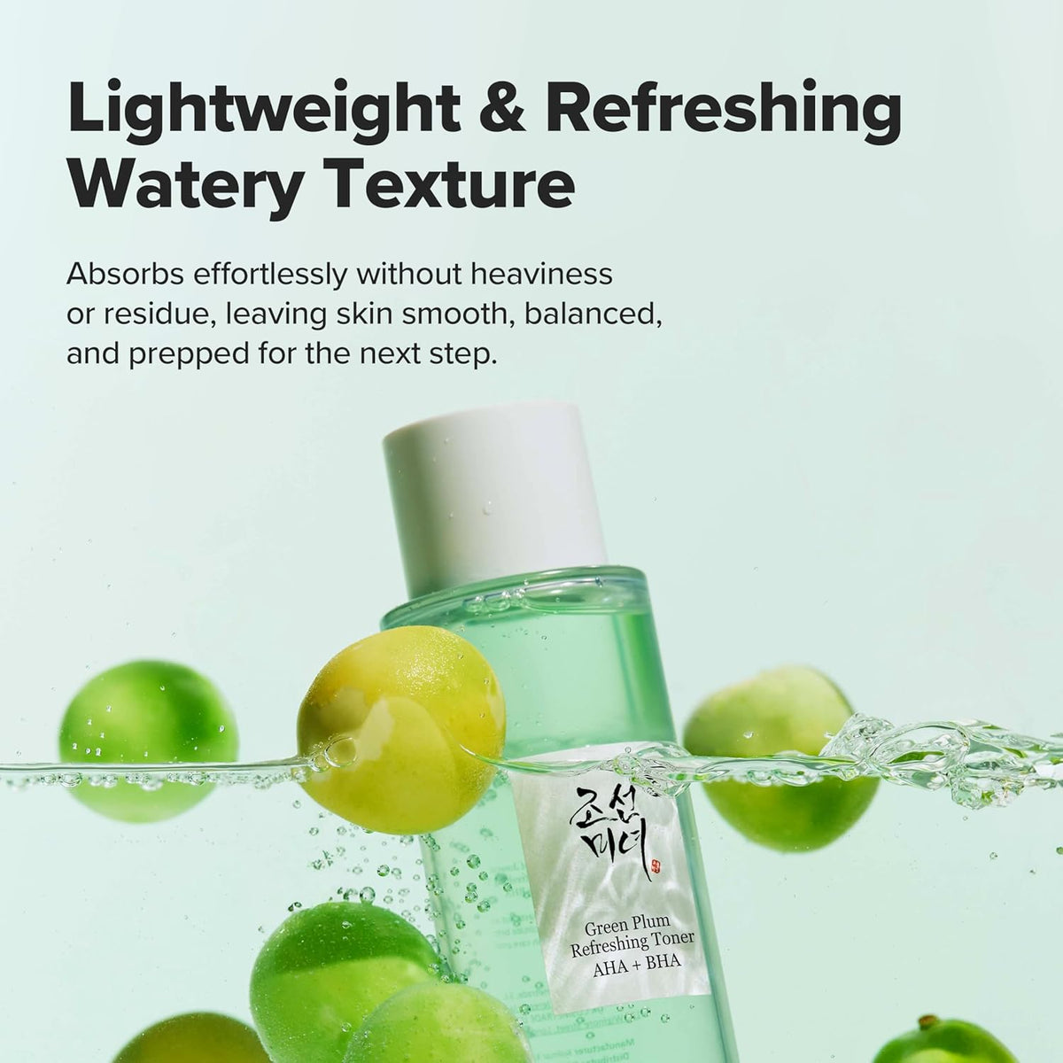 Green bottle with a white cap surrounded by green plums on a light green background