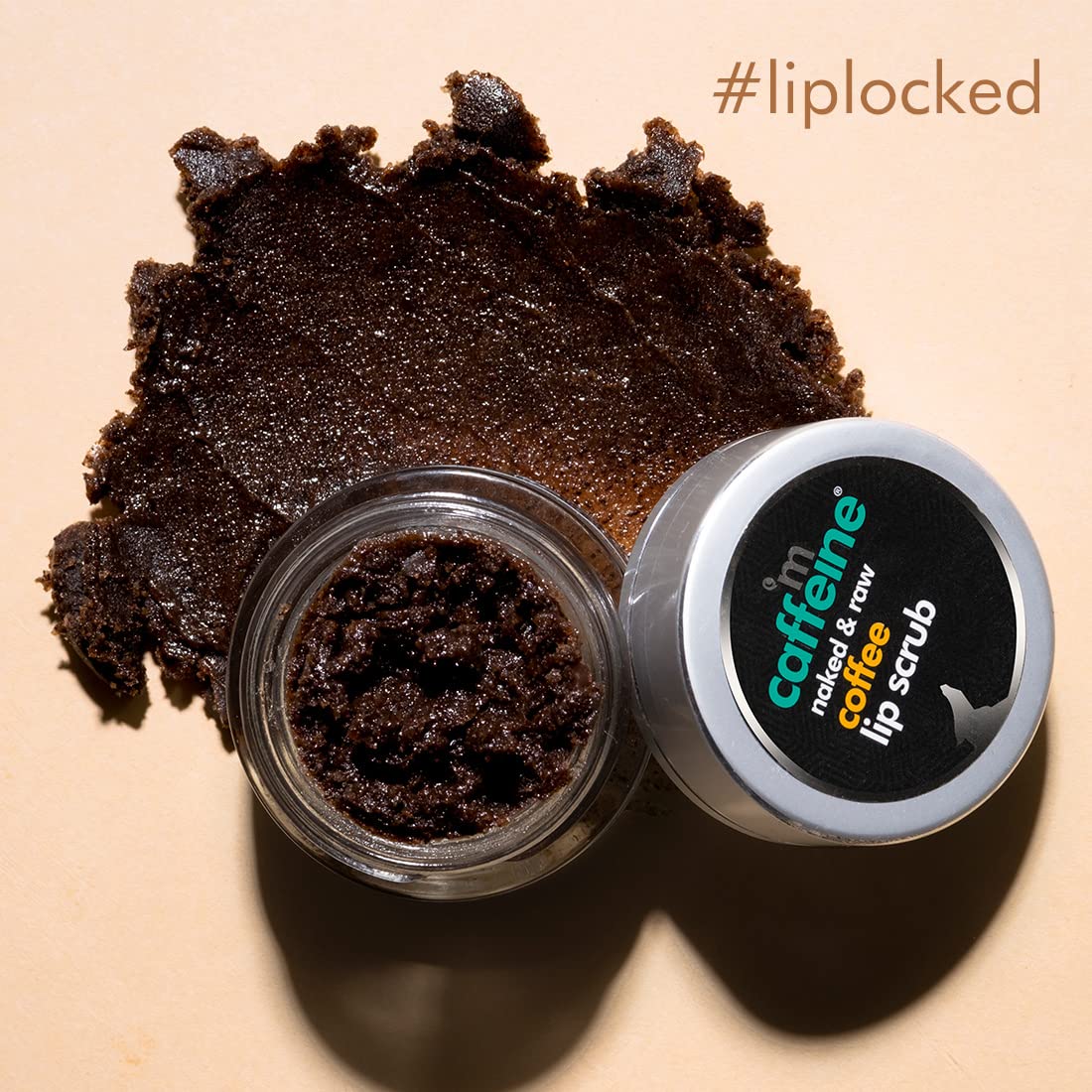 Caffeine naked & raw coffee lip scrub with open container on a beige background