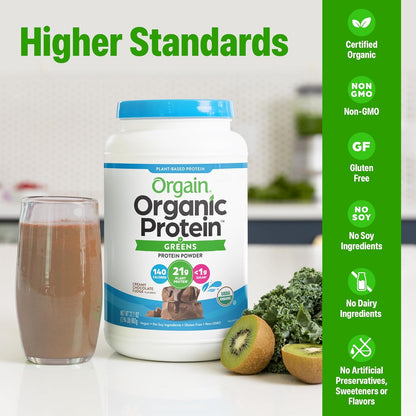 Orgain Organic Protein Greens powder container with a glass of chocolate shake and kiwi on a kitchen counter.