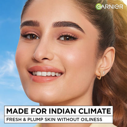 Woman with makeup and earrings against a blue sky, with Garnier branding and text about skin care.