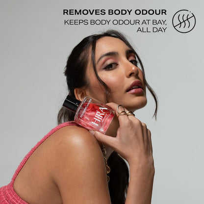 Woman holding a red Hira perfume bottle with text about odor removal on a gray background