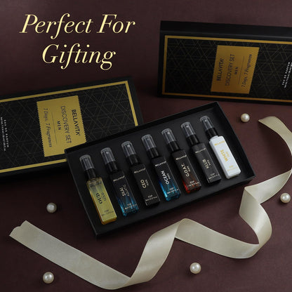 Set of small perfume bottles in a black box with decorative ribbons and pearls on a dark background.
