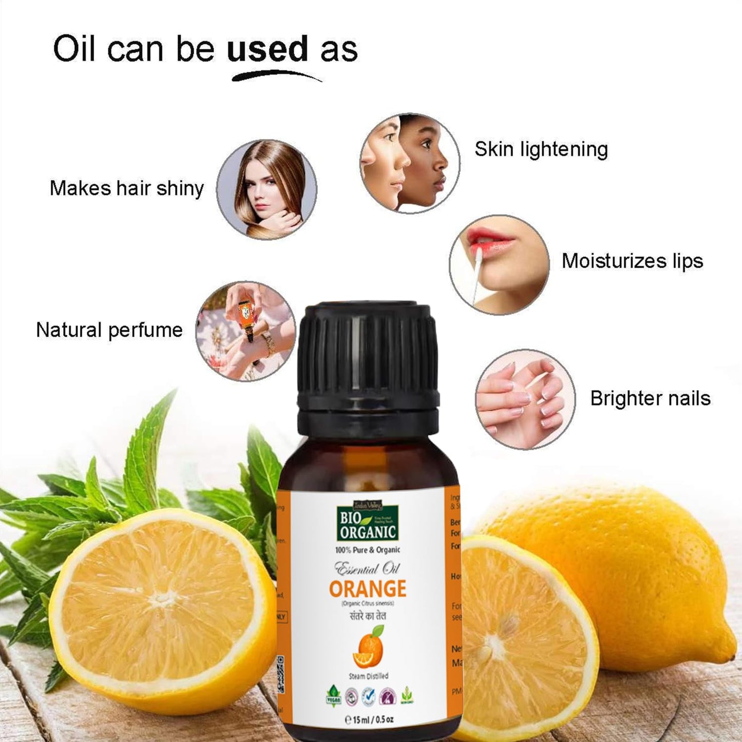 Bottle of orange essential oil with lemons and green leaves on a wooden surface, highlighting its uses.