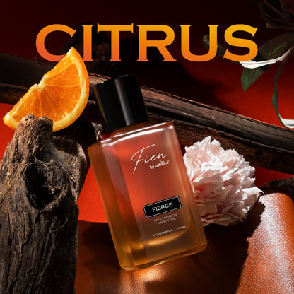 Perfume bottle labeled 'Fierce' by Fien with orange slices and a flower on a dark background.