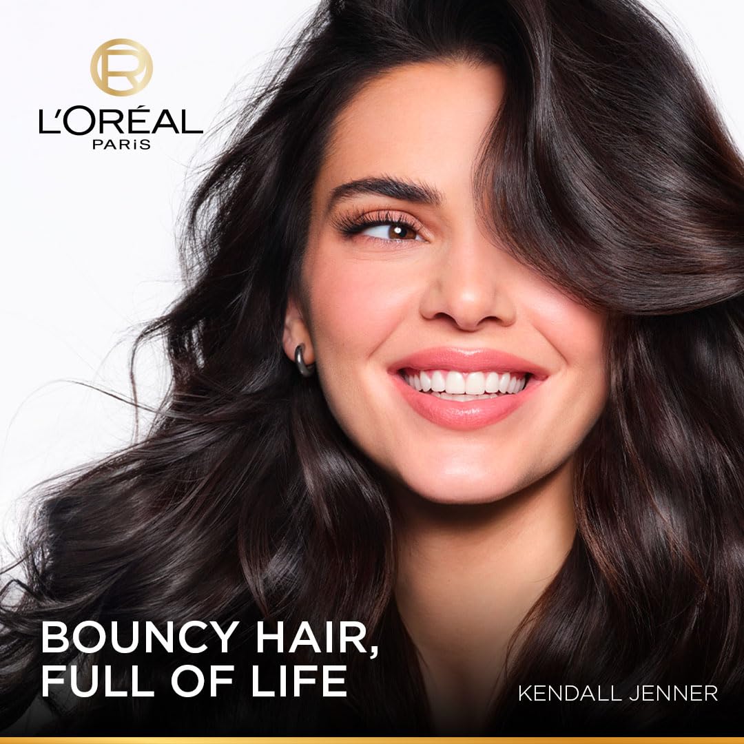 Woman with long, wavy hair smiling, L'Oreal Paris logo and text 'Bouncy Hair, Full of Life' visible
