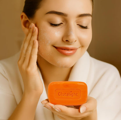 Woman applying a skincare product to her face with an orange bar of soap labeled 'Glutalight'.