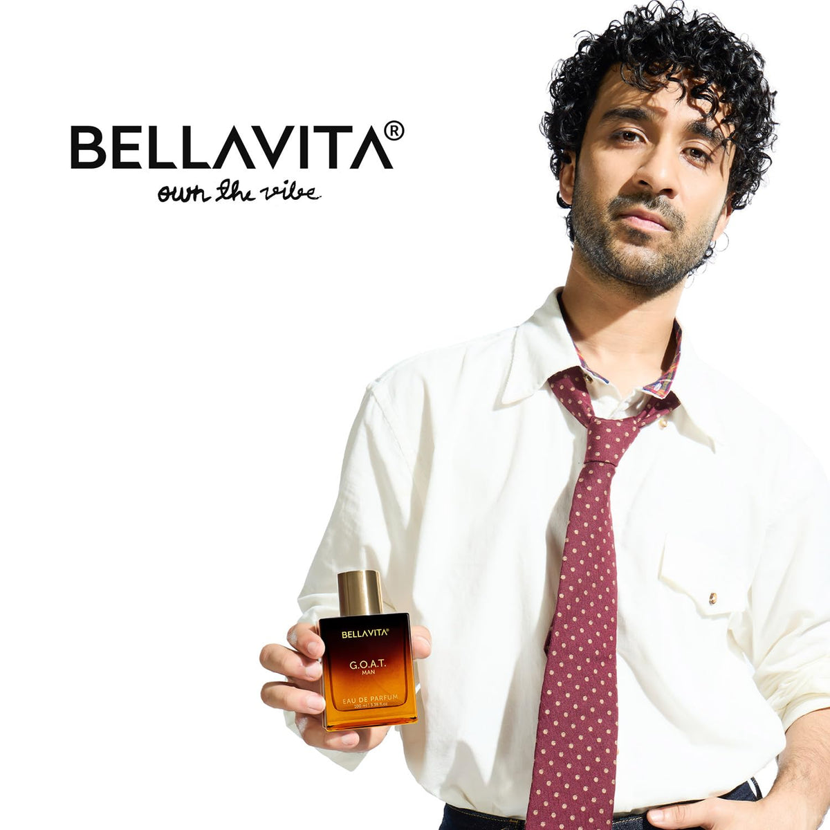 Man holding a Bellavita perfume bottle with the brand name displayed.