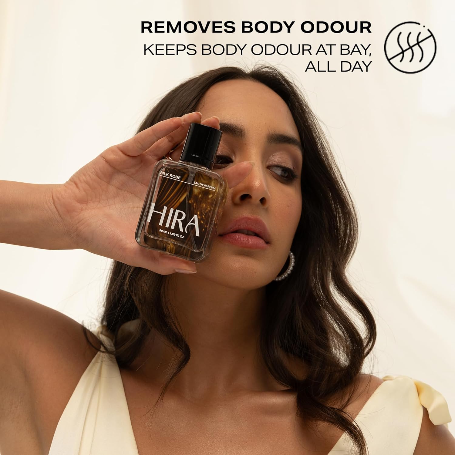 Woman holding a bottle of HIRA with text about body odor removal.