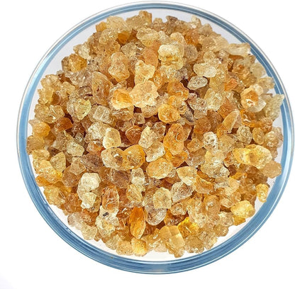 Clear glass bowl filled with amber-colored crystals on a white background