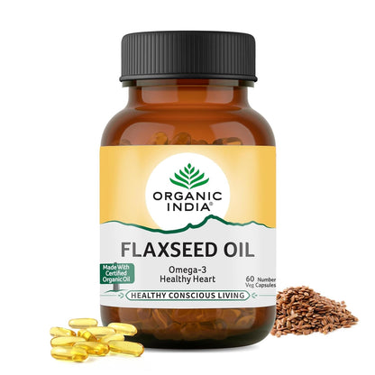 Bottle of Organic India Flaxseed Oil with capsules and seeds on a white background