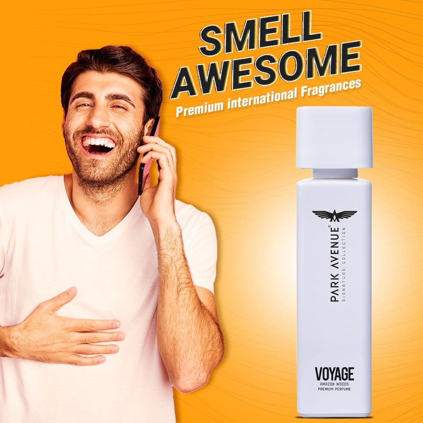 Man talking on phone with Park Avenue Voyage perfume bottle on an orange background