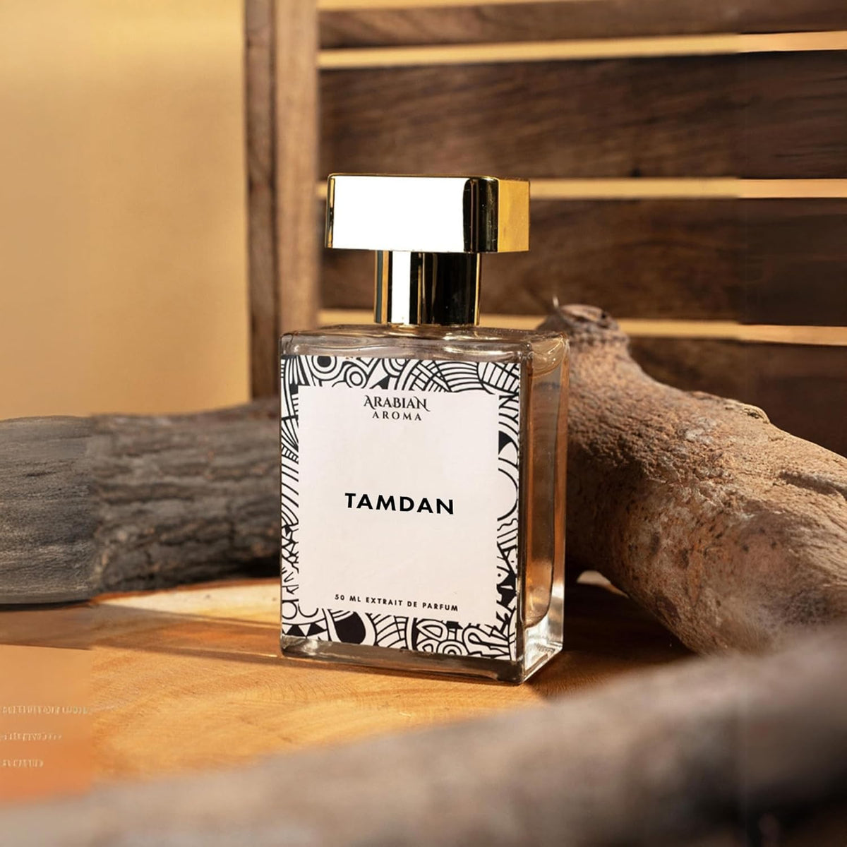Perfume bottle labeled 'Tamdan' by Arabian Leather on a wooden surface with natural elements.