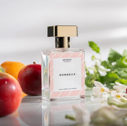 Perfume bottle labeled 'Bombelle' with fruits and flowers in the background