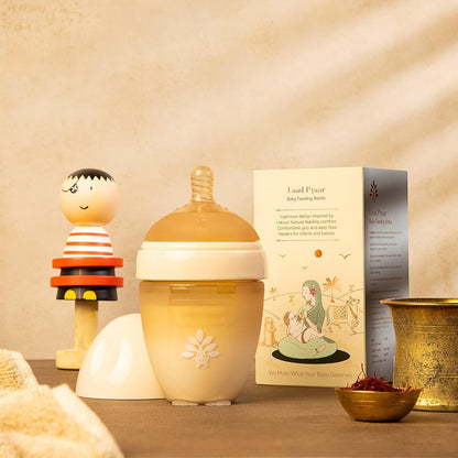 Baby bottle with packaging and decorative items on a wooden surface