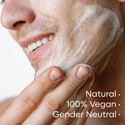 Close-up of a person applying a skincare product to their face with text indicating 'Natural', '100% Vegan', and 'Gender Neutral'.