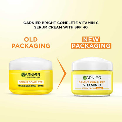 Comparison of Garnier Bright Complete Vitamin C Serum Cream with SPF 40 old and new packaging on a yellow background.