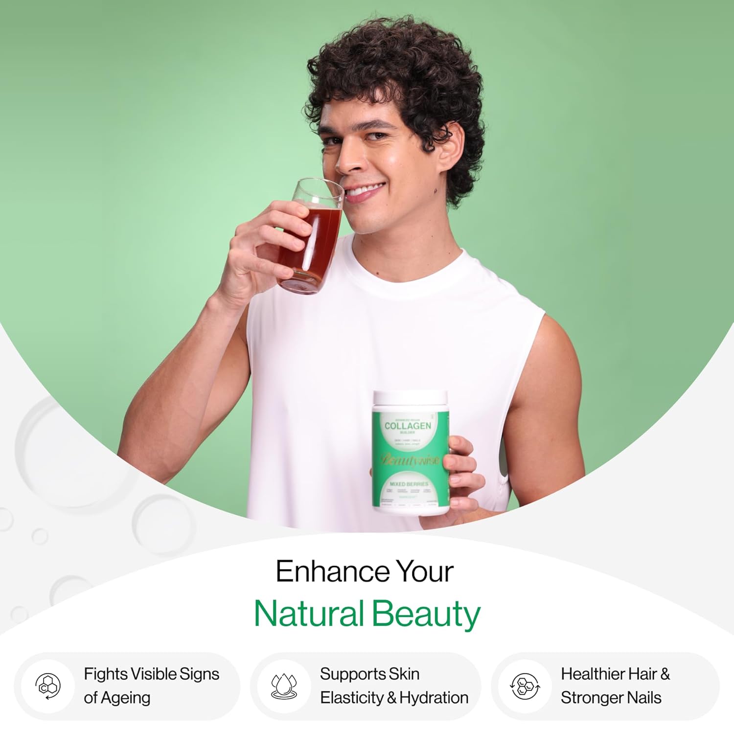 Man holding a glass of juice and a container with text about enhancing natural beauty on a green background