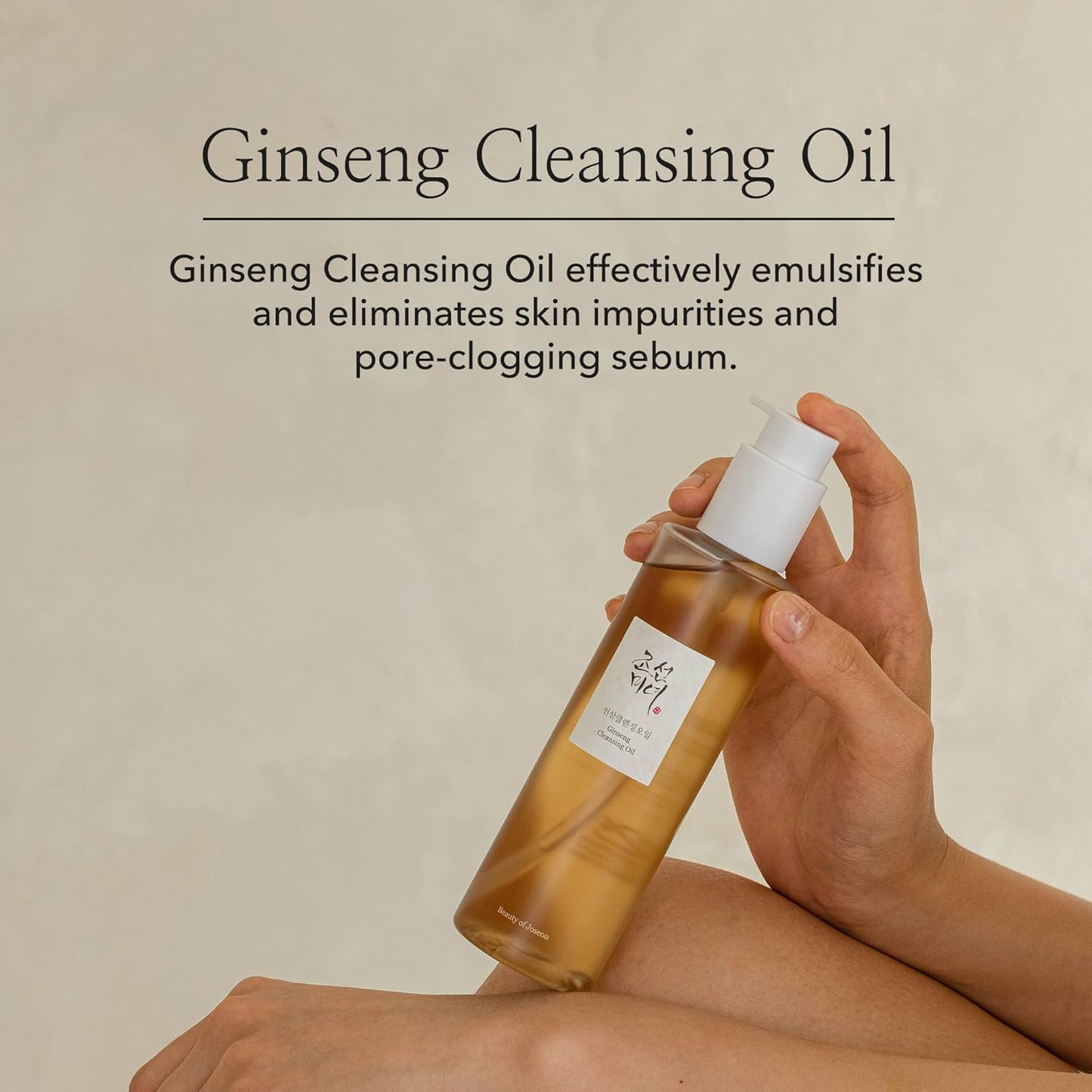 Hand holding a bottle of Ginseng Cleansing Oil with text on a beige background