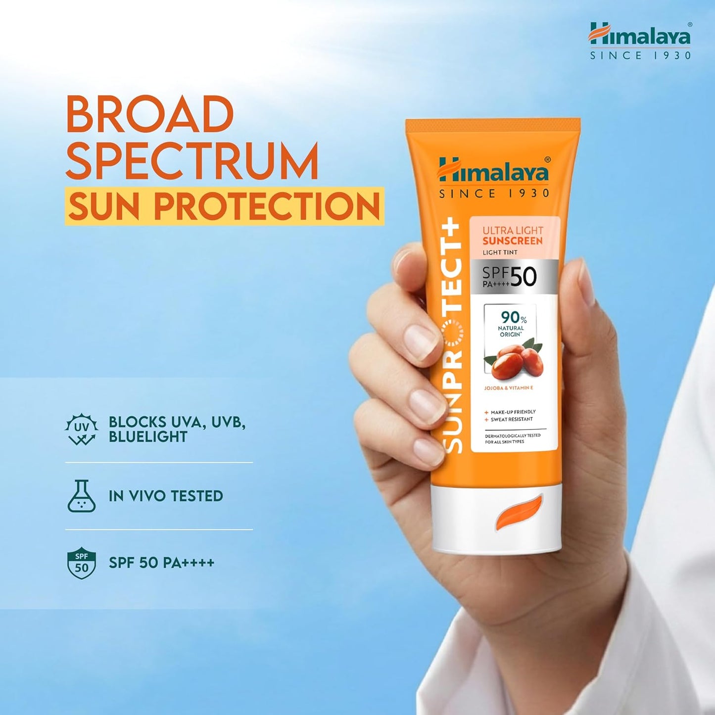 Himalaya Sun Protect+ sunscreen tube held in a hand with a blue background
