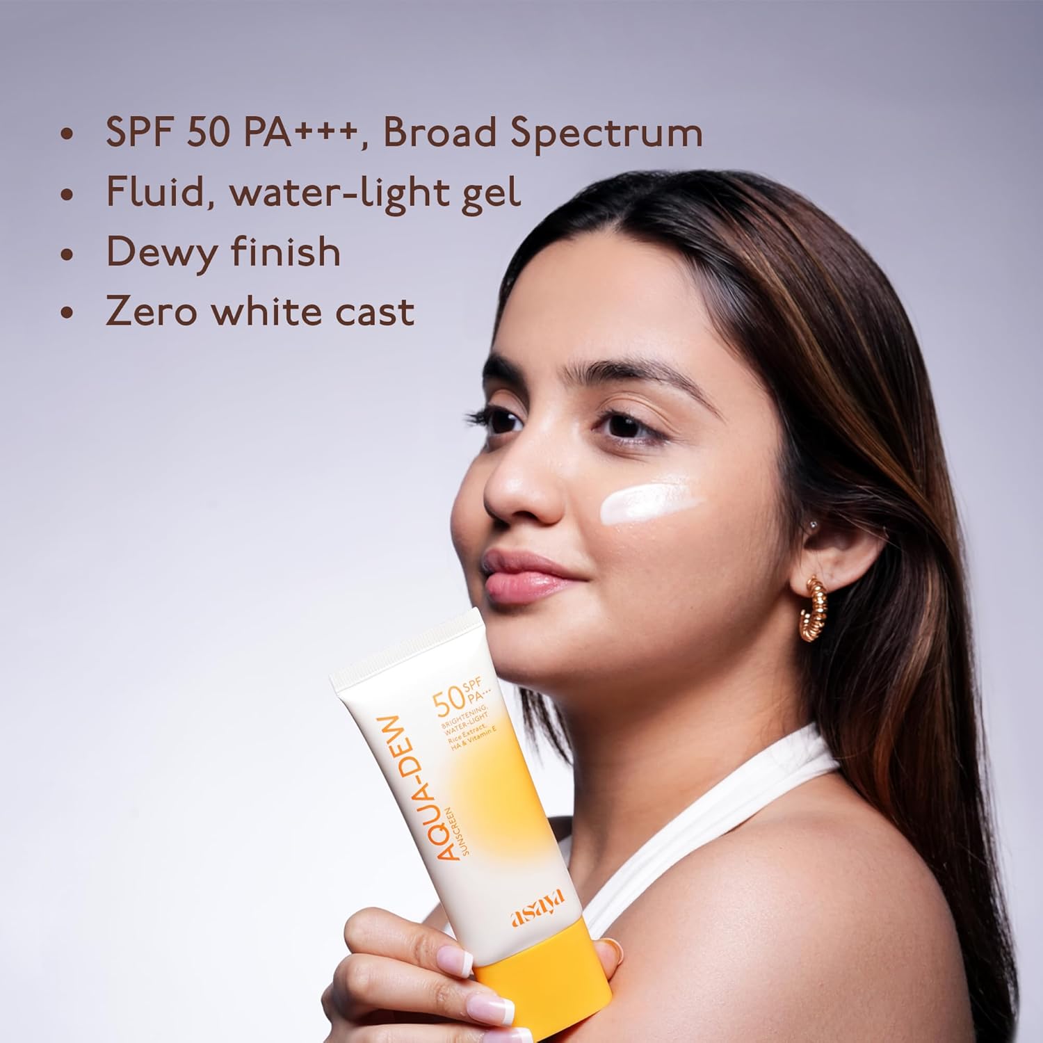Woman holding a sunscreen product with text detailing its features on a gray background