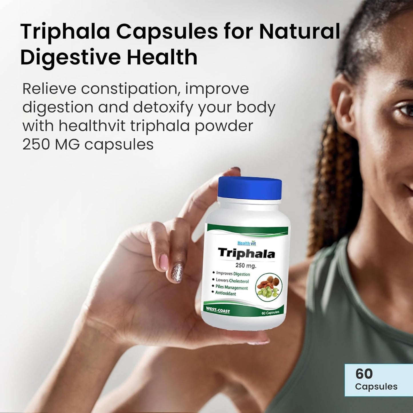 Person holding a bottle of Triphala capsules with product details on a light gray background