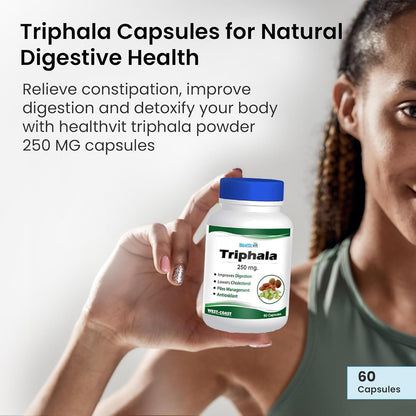 Person holding a bottle of Triphala capsules with product details on a light gray background