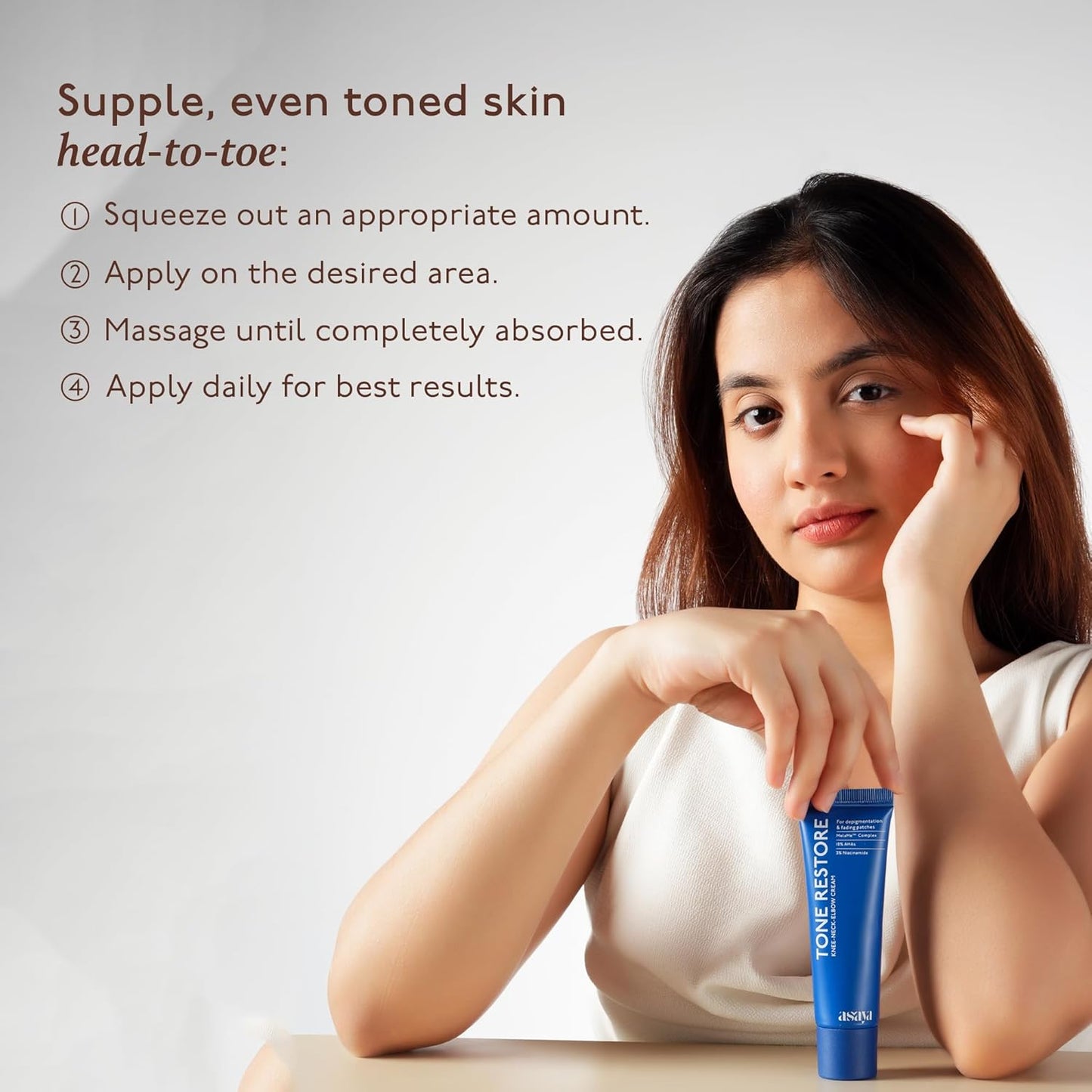 Woman with a skincare product and instructions for supple, even-toned skin on a white background