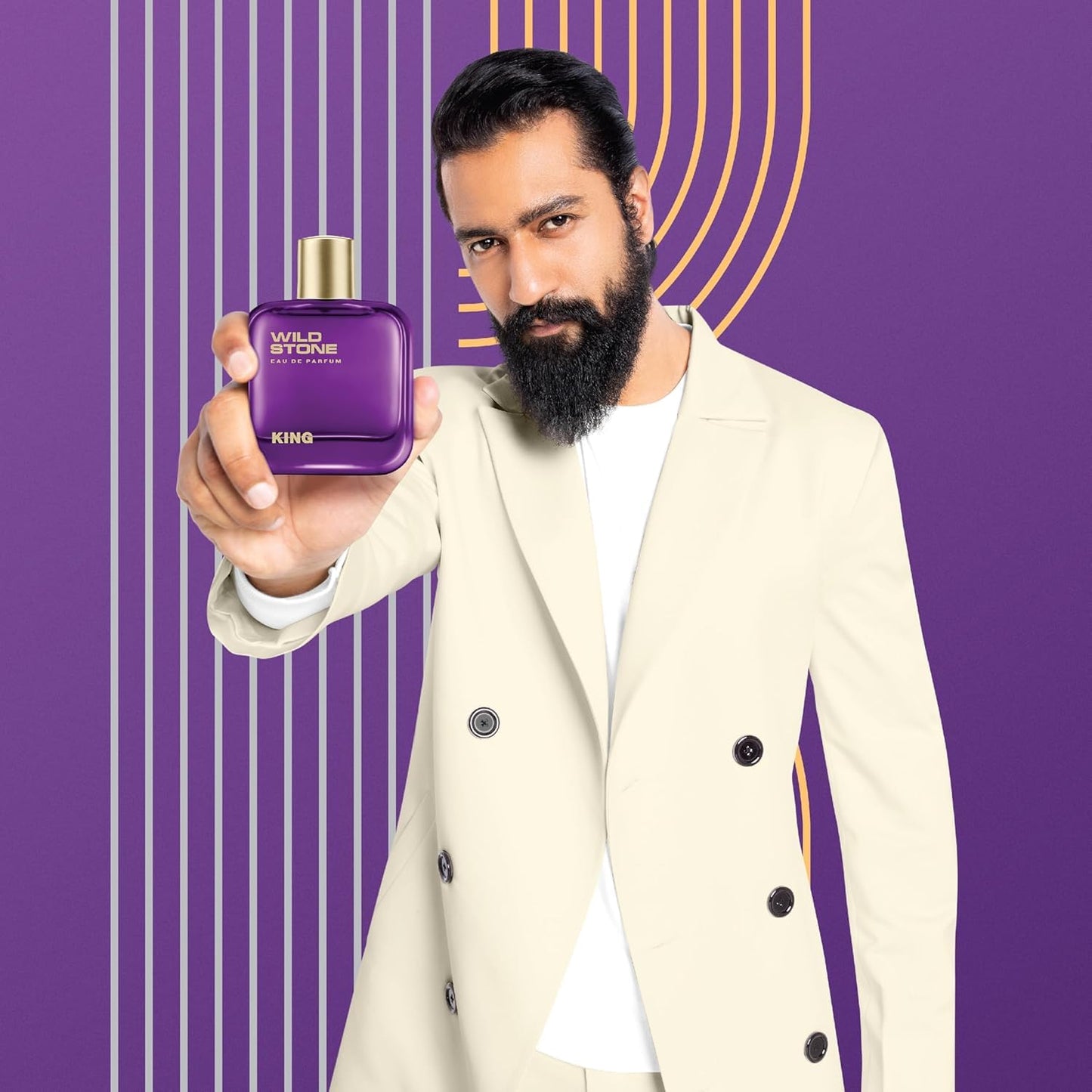 Man holding a purple Wild Stone King perfume bottle against a purple background