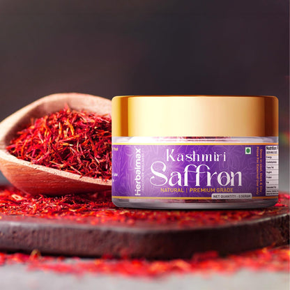 Jar of Kashmiri Saffron with saffron strands on a wooden spoon and surface.