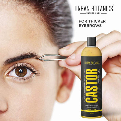 Person applying Urban Botanics Castor Oil to eyebrows with a dropper, featuring the brand's logo.