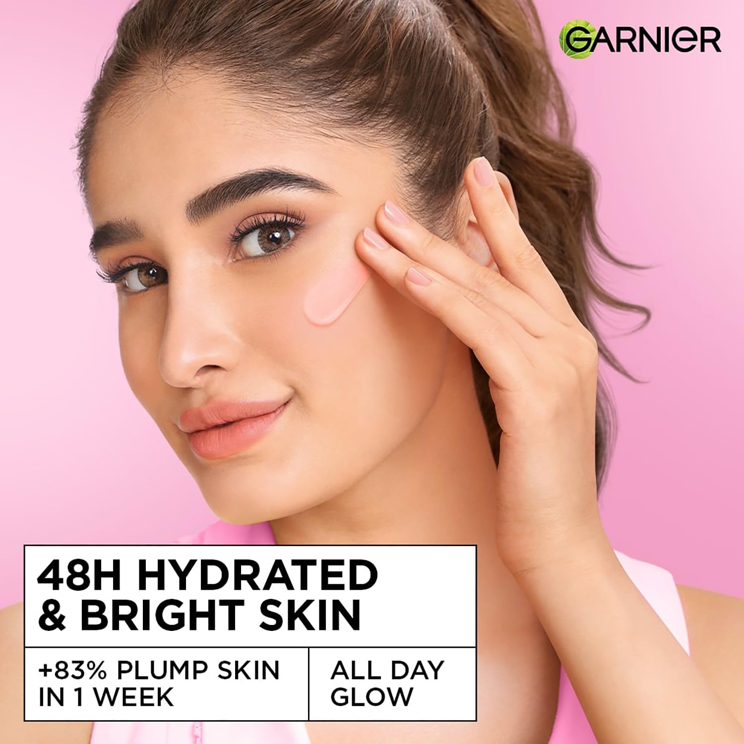 Woman applying skincare product with Garnier logo on pink background