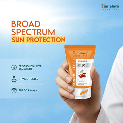 Himalaya Sun Protect+ sunscreen cream packaging held in a hand with promotional text on a blue background