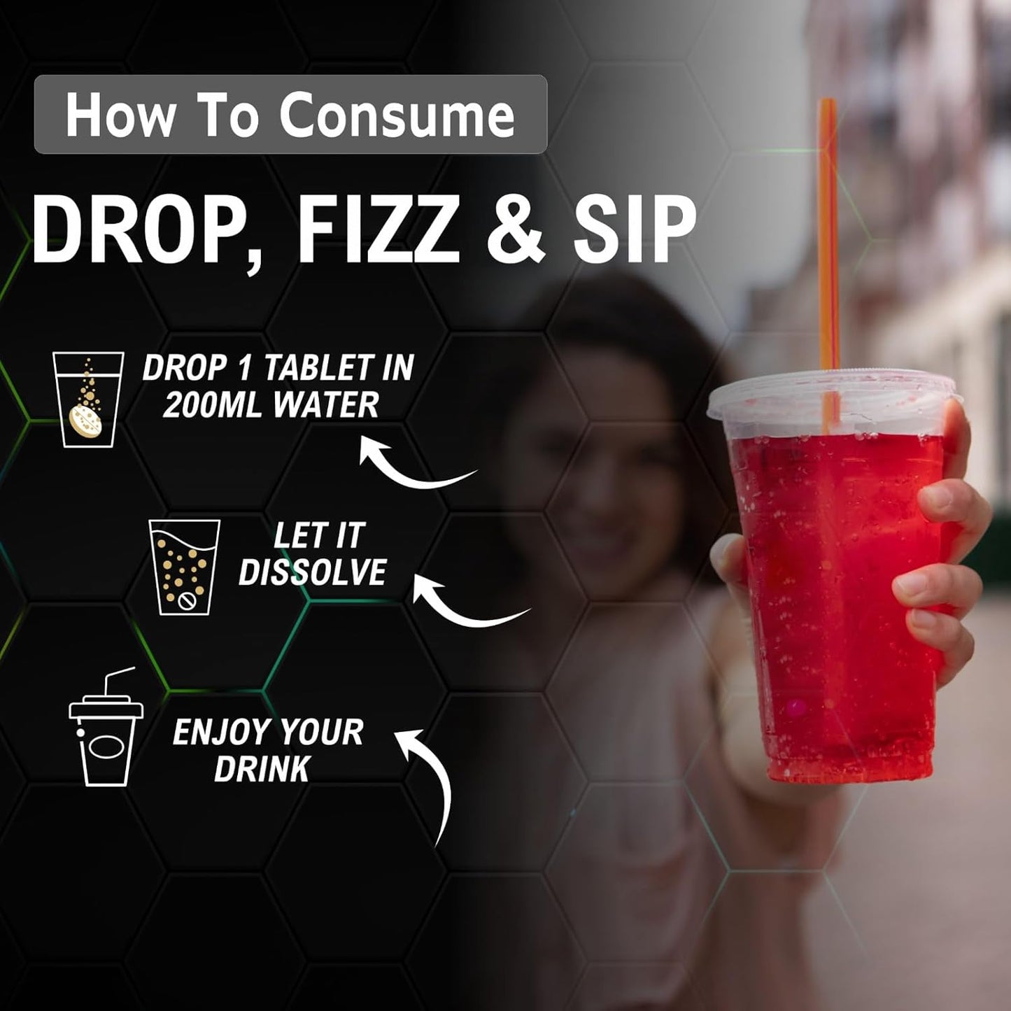 Red drink in a plastic cup with a straw, held by a person, against a blurred background.