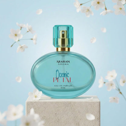 Blue perfume bottle labeled 'Arabian Aroma Oceanic Petal' on a light blue background with white flowers.