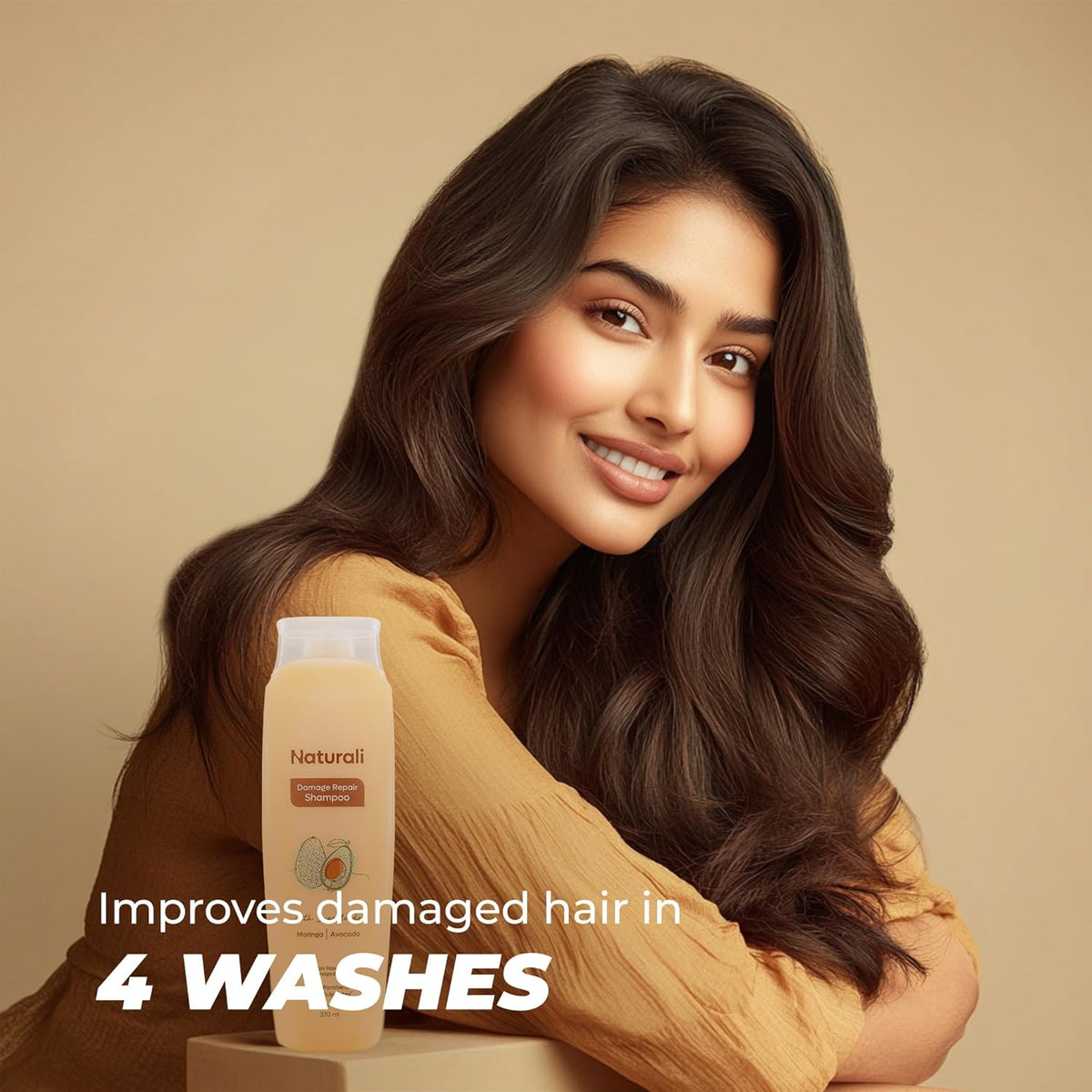 Woman with long, wavy hair next to a bottle of shampoo on a beige background