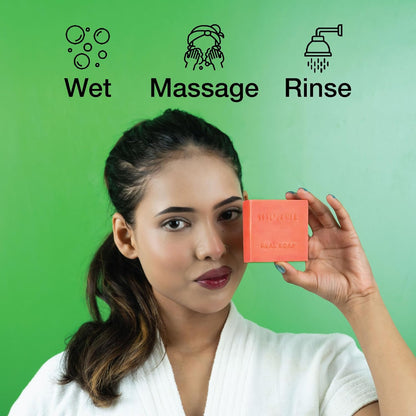 Woman holding a bar of soap with icons and text for wetting, massaging, and rinsing on a green background.