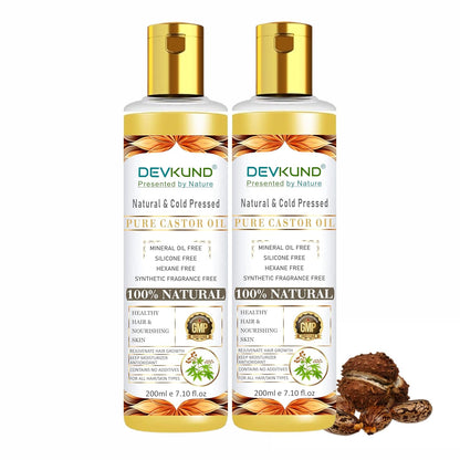 Two bottles of Devkund Pure Castor Oil on a white background with castor seeds.