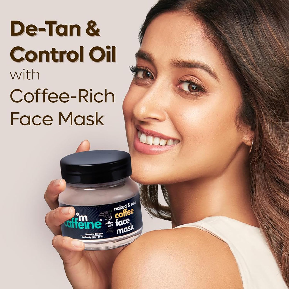Woman holding a jar of 'm'caffeine coffee-rich face mask with text about de-tan and control oil.