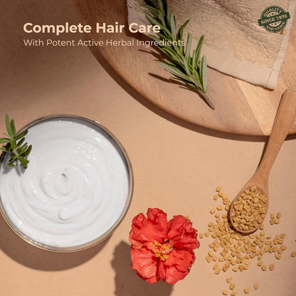 Hair care product with herbs, flower, and seeds on a wooden surface