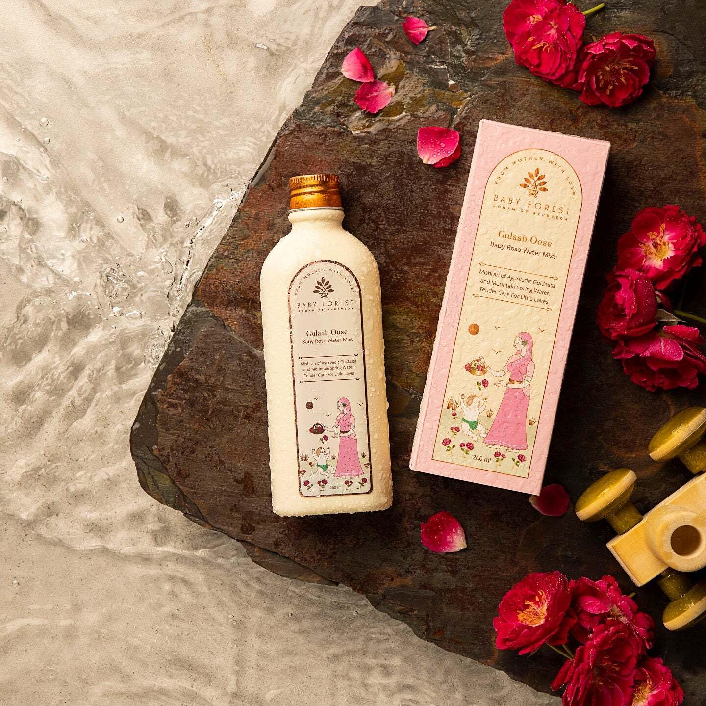 Baby lotion bottle and packaging with flowers on a stone surface
