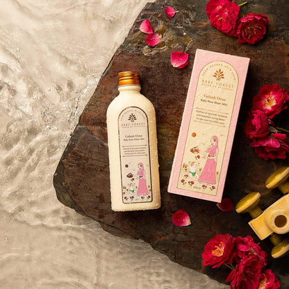 Baby lotion bottle and packaging with flowers on a stone surface