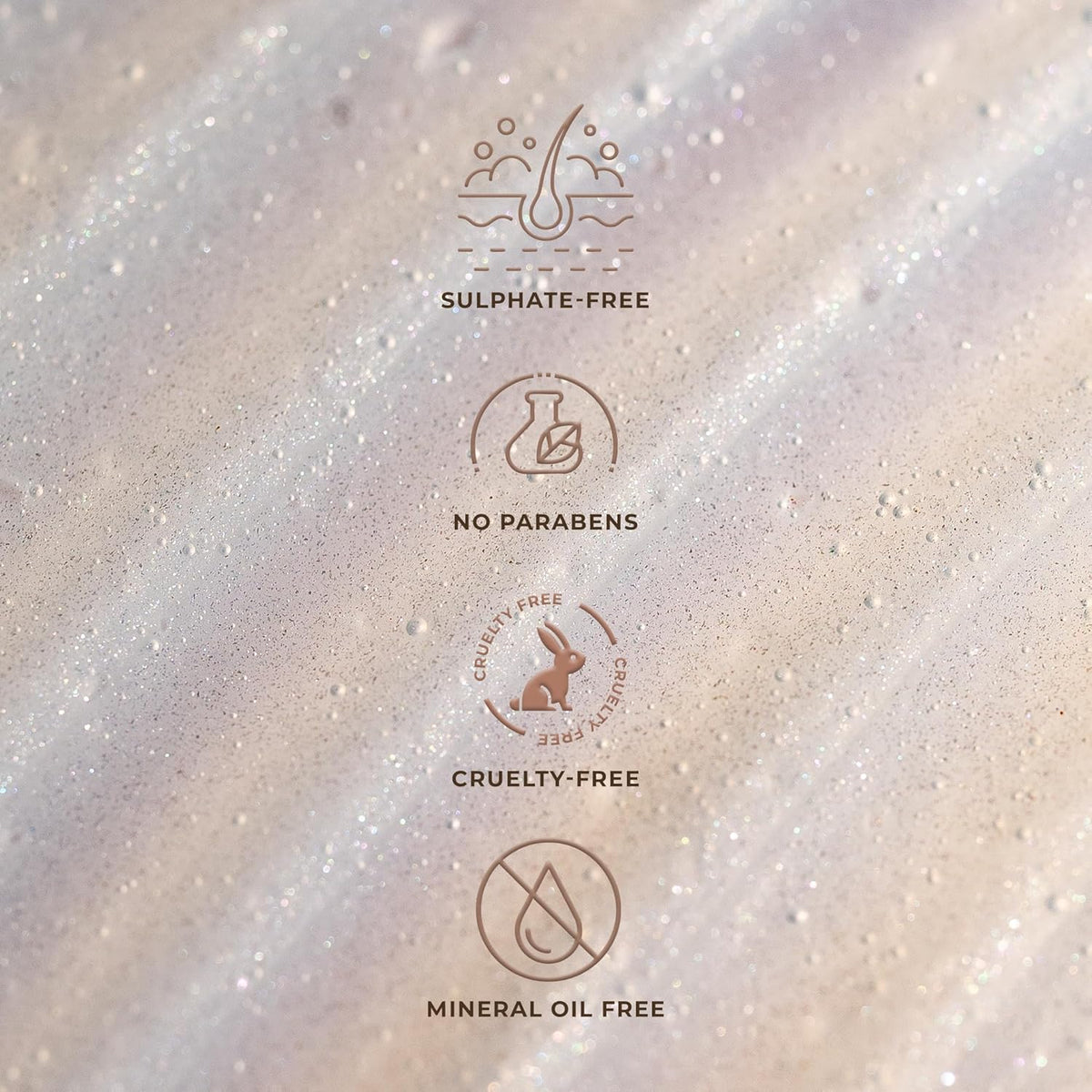 Product label with icons and text indicating sulfate-free, no parabens, cruelty-free, and mineral oil-free on a textured background.
