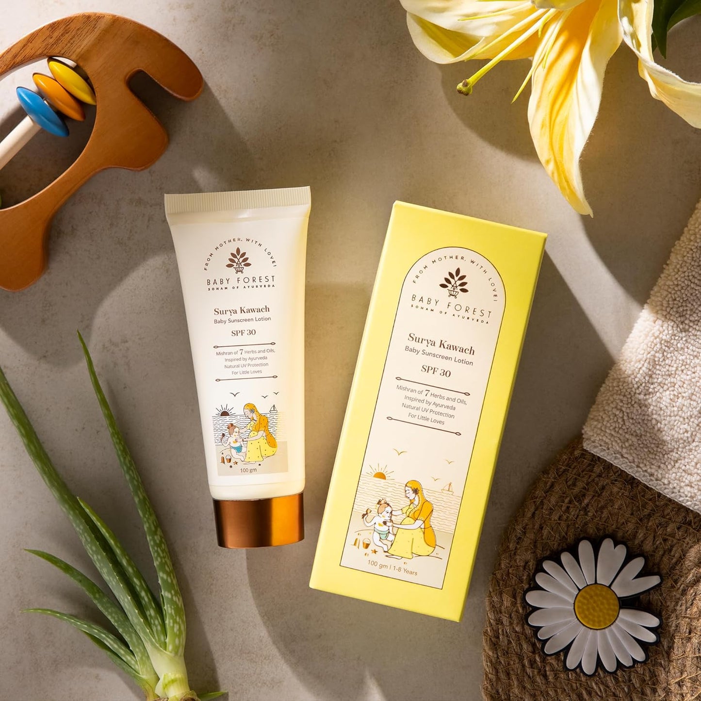 Baby lotion tube and packaging on a textured surface with flowers and a plant.