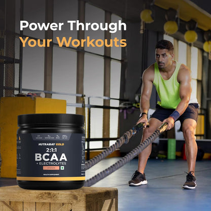 Person using battle ropes with a supplement container labeled 'NutraKey Gold BCAA' in a gym setting.