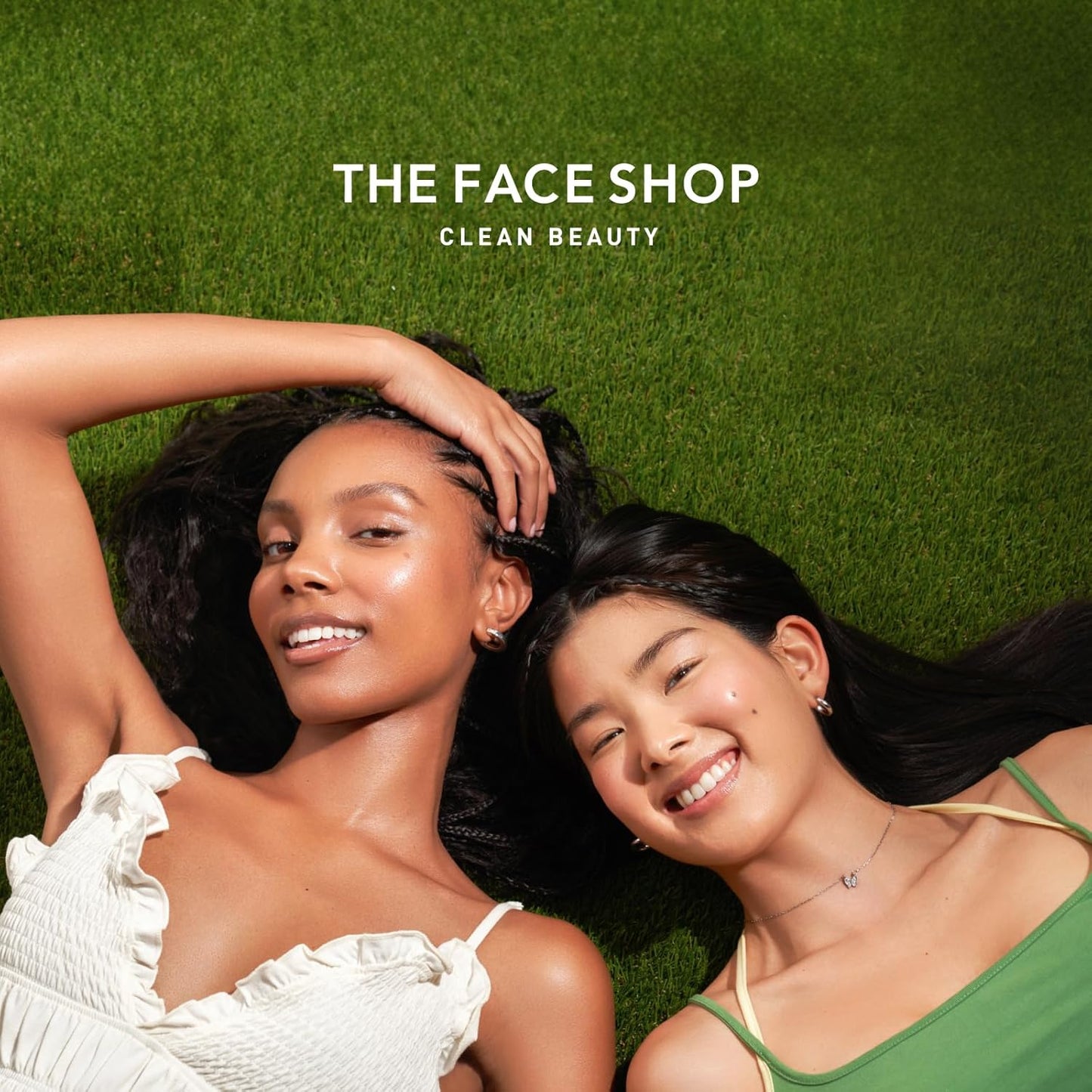 Two women lying on grass with 'The Face Shop' logo above them.