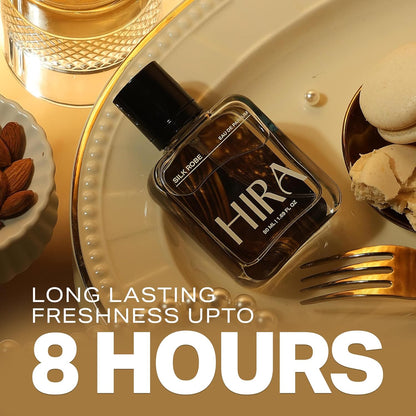Perfume bottle labeled 'Hira' on a decorative plate with text about longevity, surrounded by almonds and cookies.